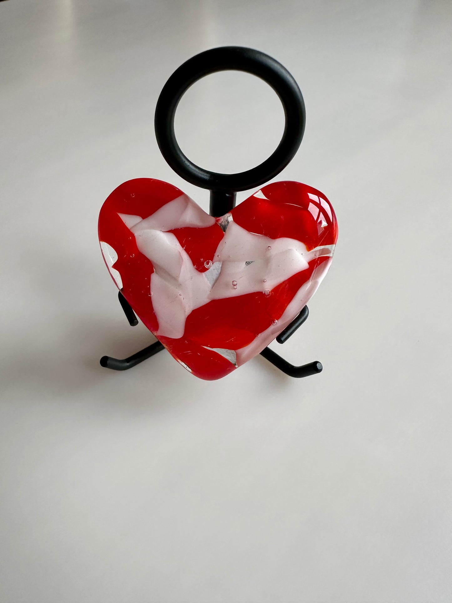 A Metal Person holding a Fused Glass Heart