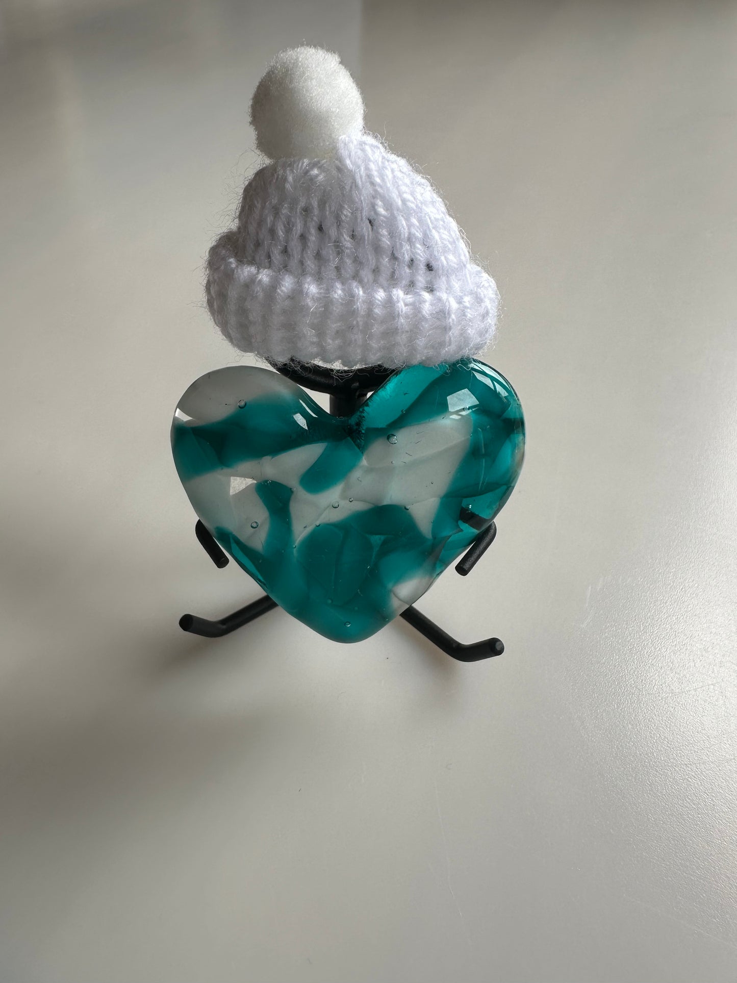 A Metal Person holding a Fused Glass Heart