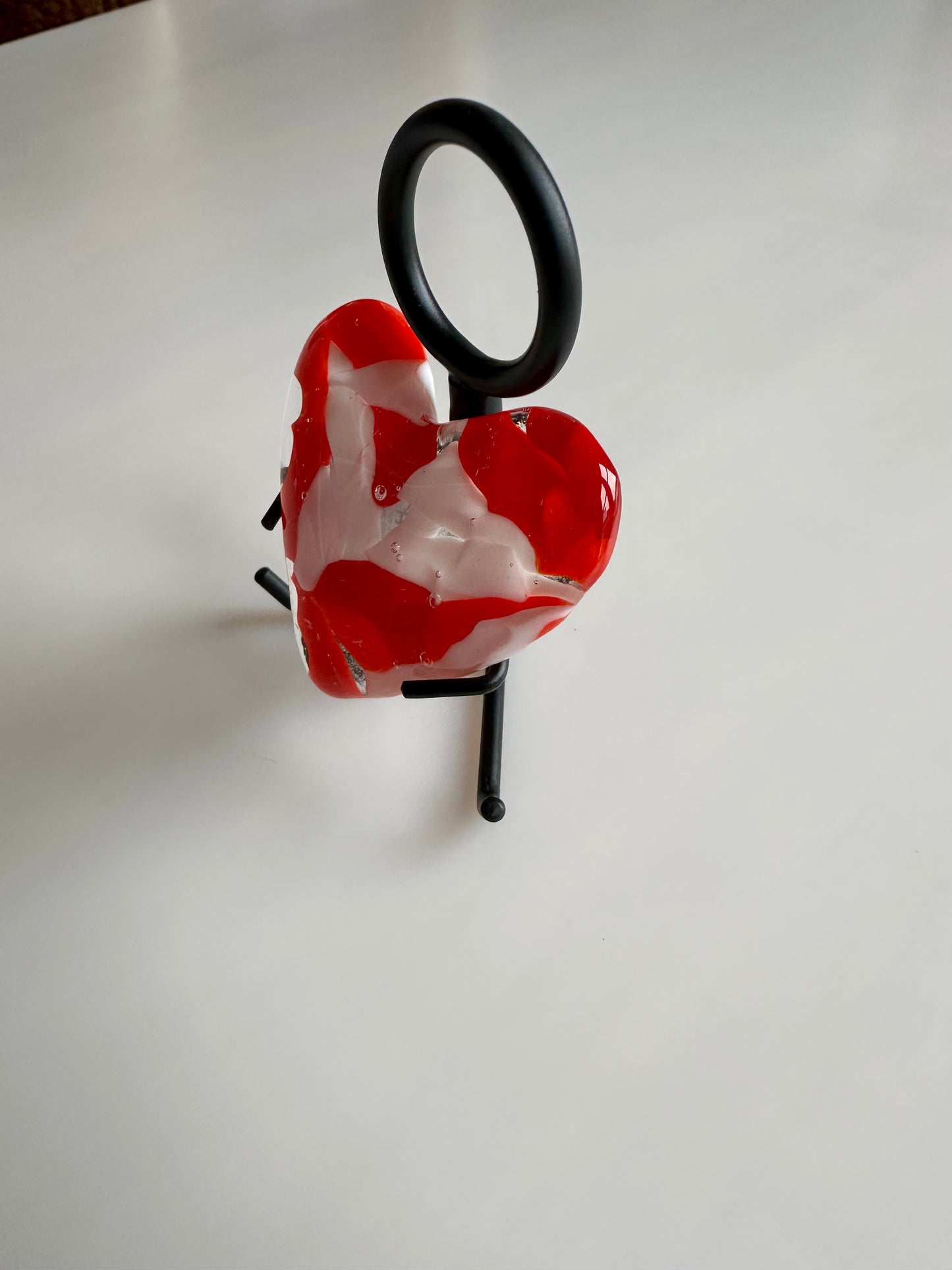 A Metal Person holding a Fused Glass Heart