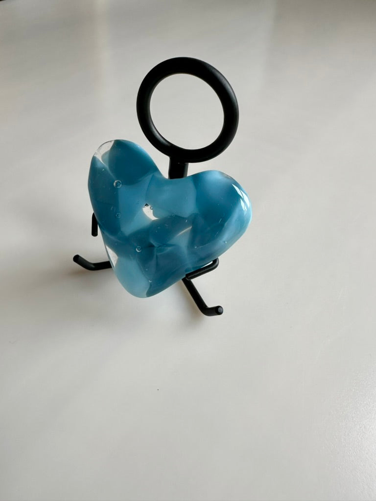 A Metal Person holding a Fused Glass Heart