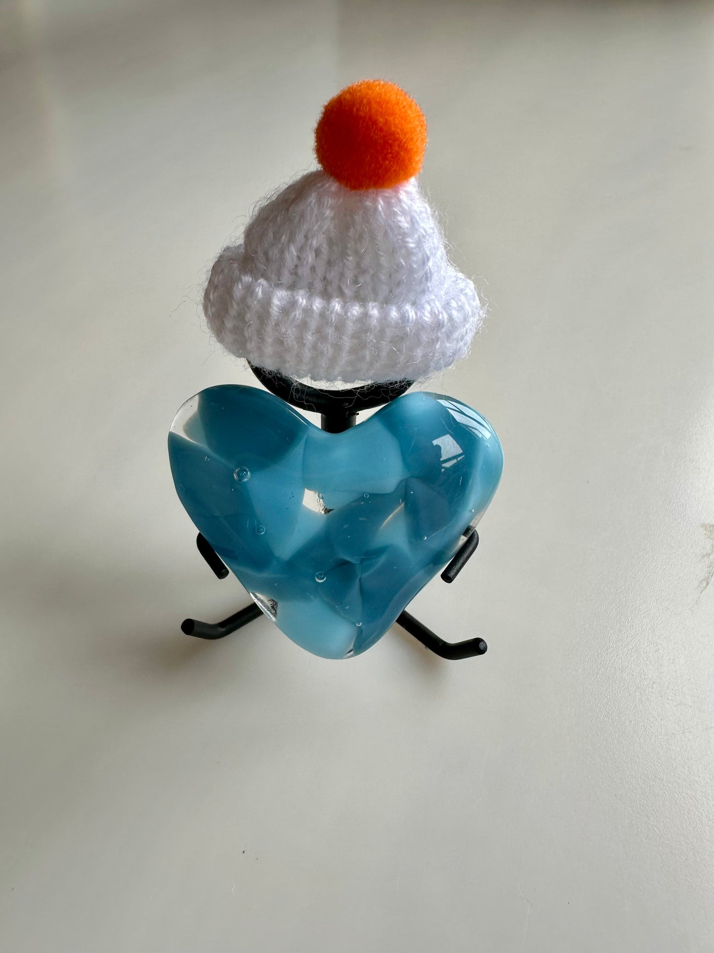 A Metal Person holding a Fused Glass Heart